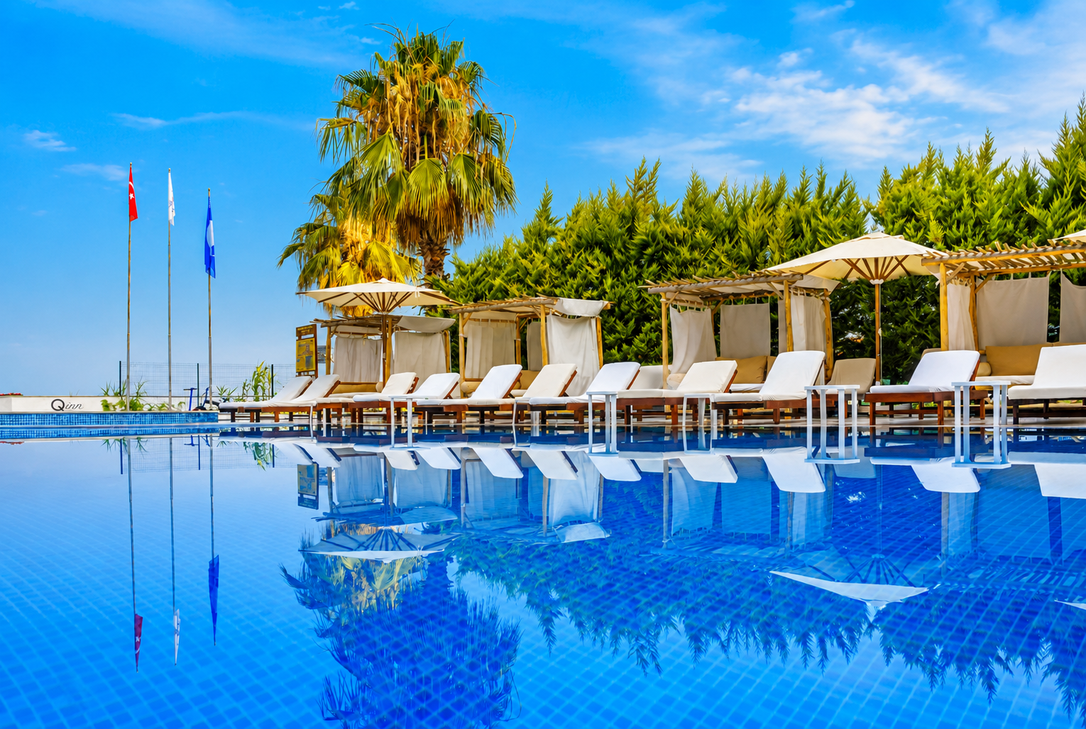 Qinn Hotels havuzunda gökyüzü yansıması ve kabinler